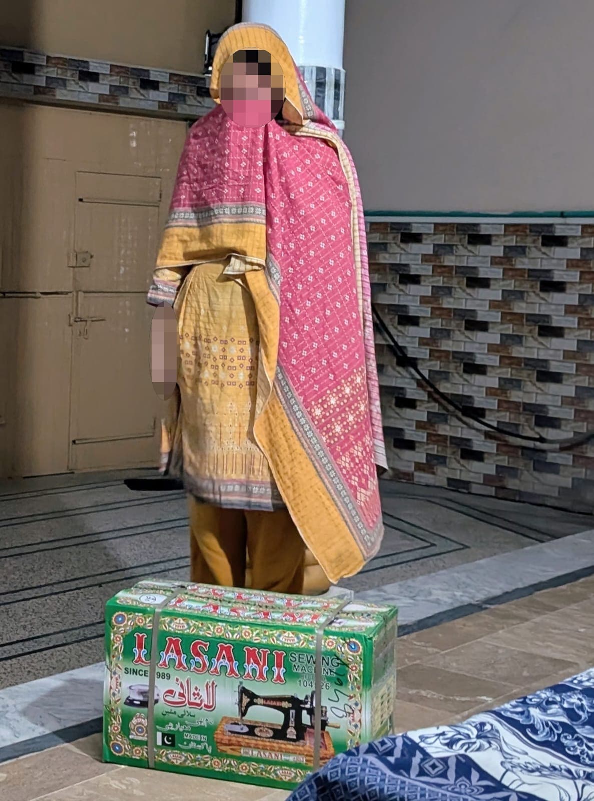 A woman in pink stands beside a boxed sewing machine